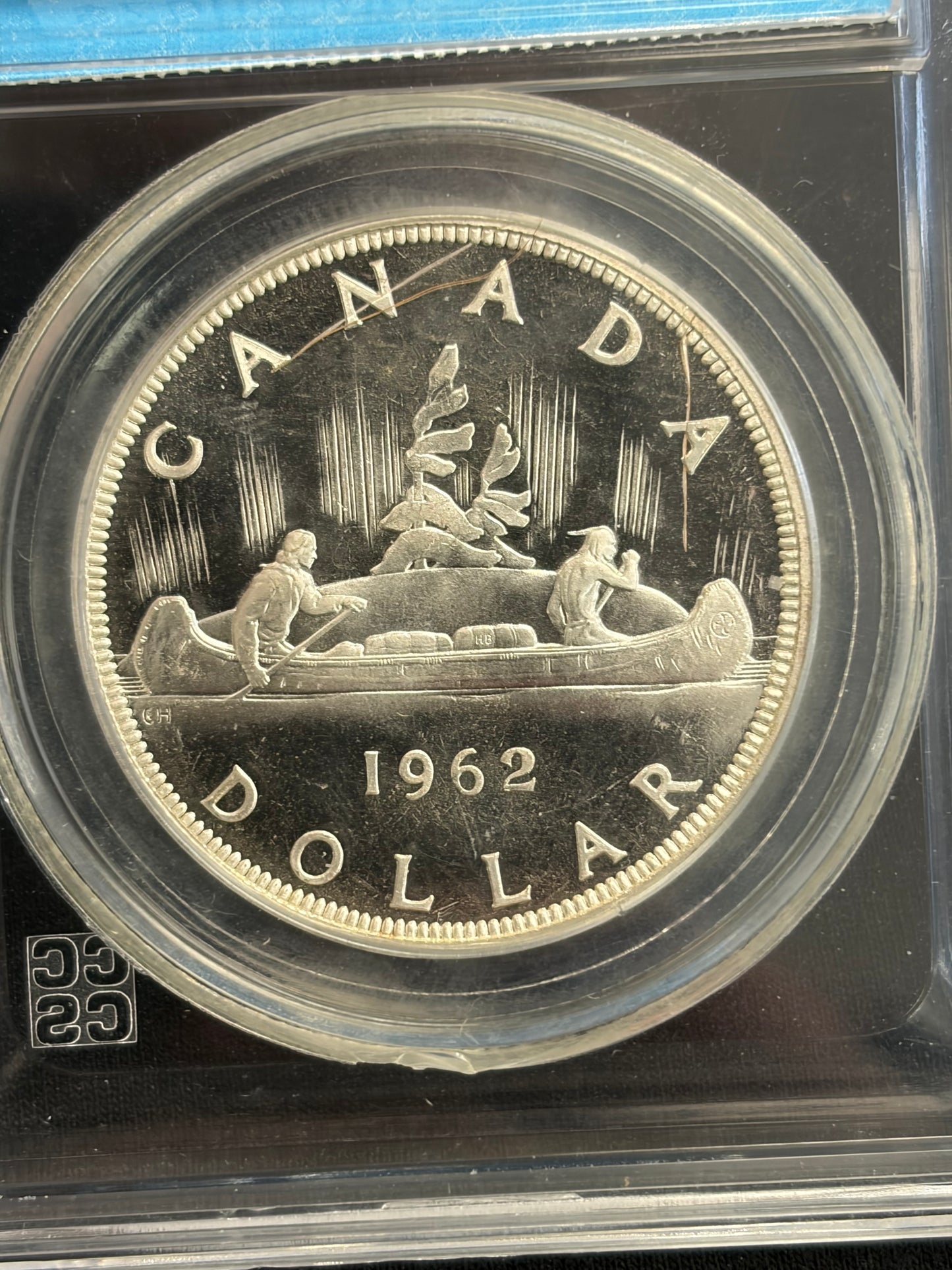 1962 Canada 1 Dollar. CCCS graded PL-65. Extremely Rare Error. Struck through hair with the hair still attached!